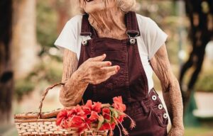 Elderly woman holding a basket of flowers